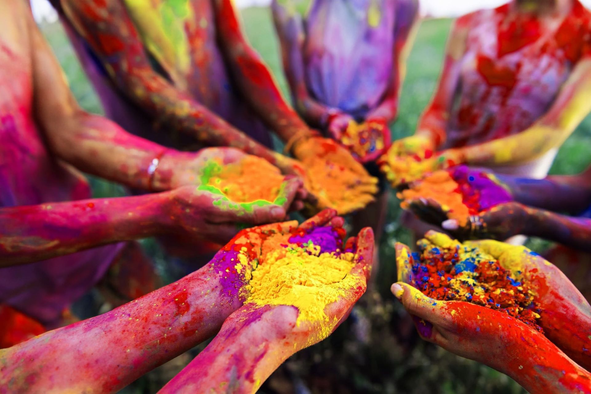 Plusieurs personnes qui tiennent des poudres colorées dans les mains en Inde durant la fête Holi